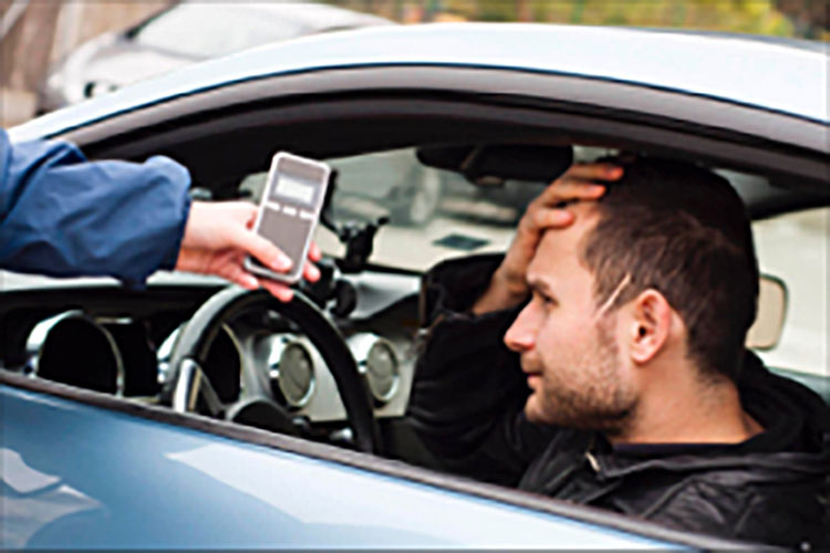 Man in car taking roadside breathalyzer test